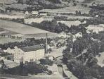Nedatovaný historický obrázek, komín s rozůstající se fabrikou v popředí